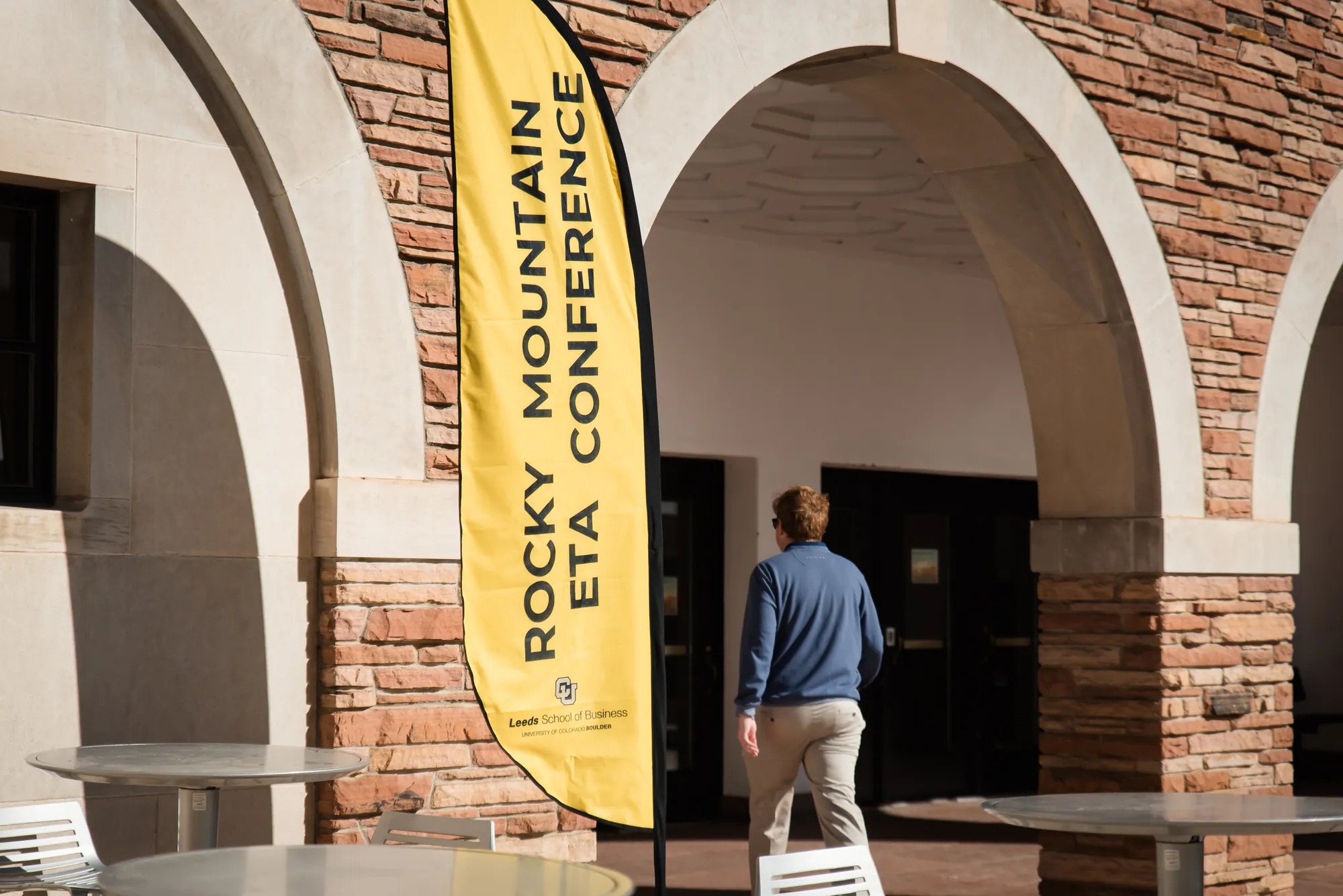 A Rocky Mountain ETA Conference banner standing under the sandstone arches of the University of Colorado Boulder