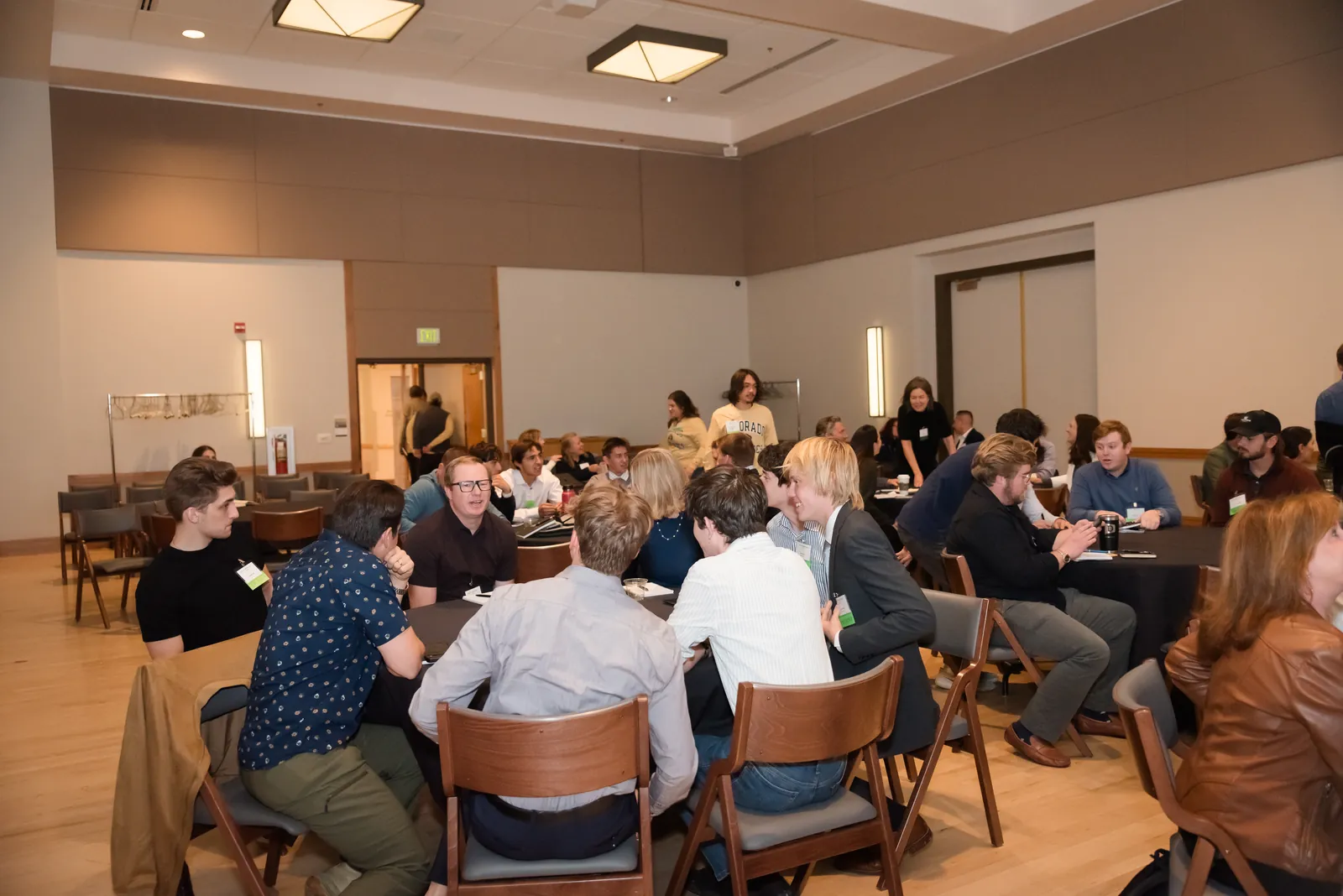 Attendees working in small groups around tables during a workshop