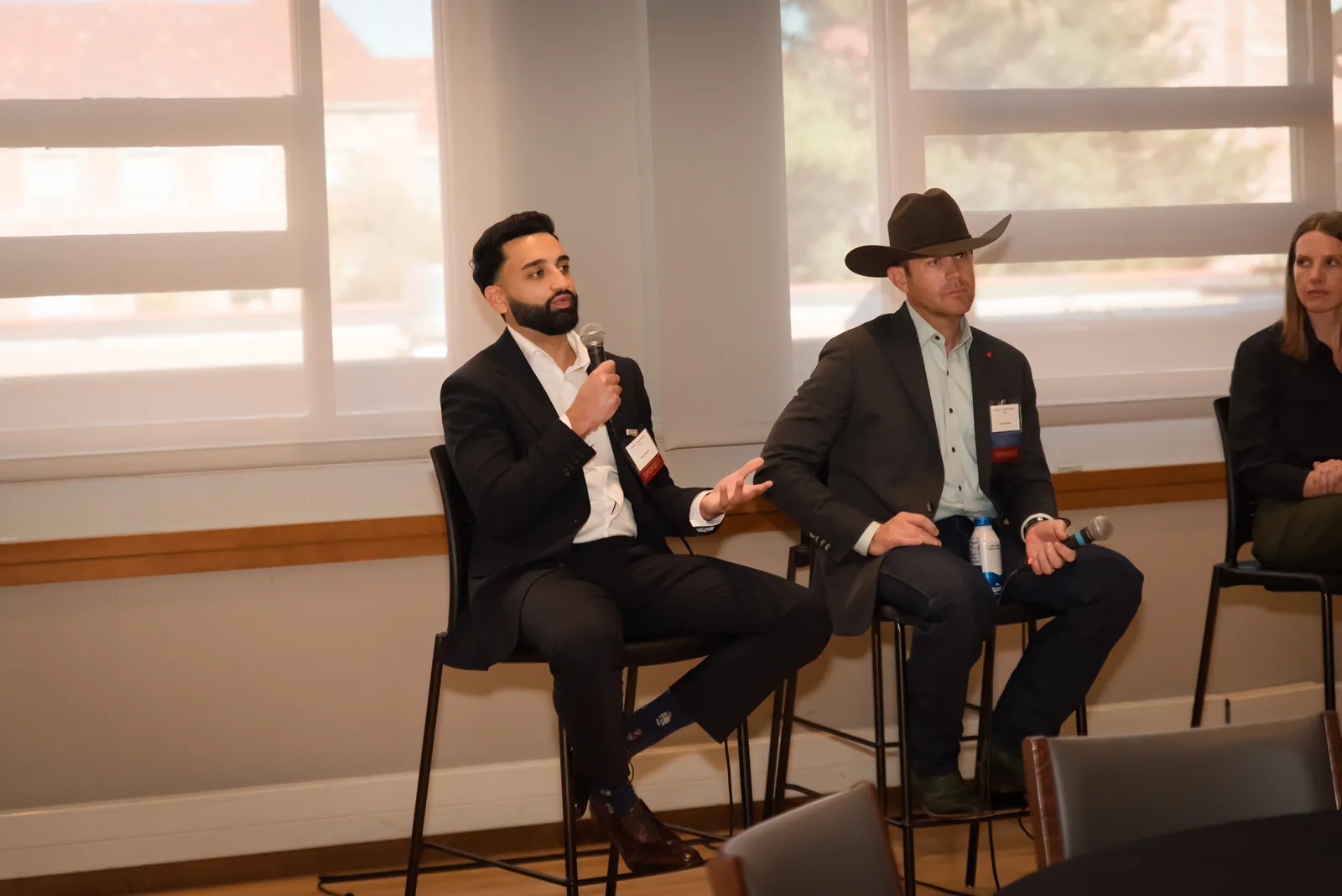 A panellist speaking into a microphone while the room listens